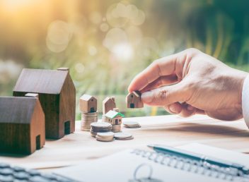 House placed on coins Men's hand is planning savings money of coins to buy a home concept concept for property ladder, mortgage and real estate investment. for saving or investment for a house,